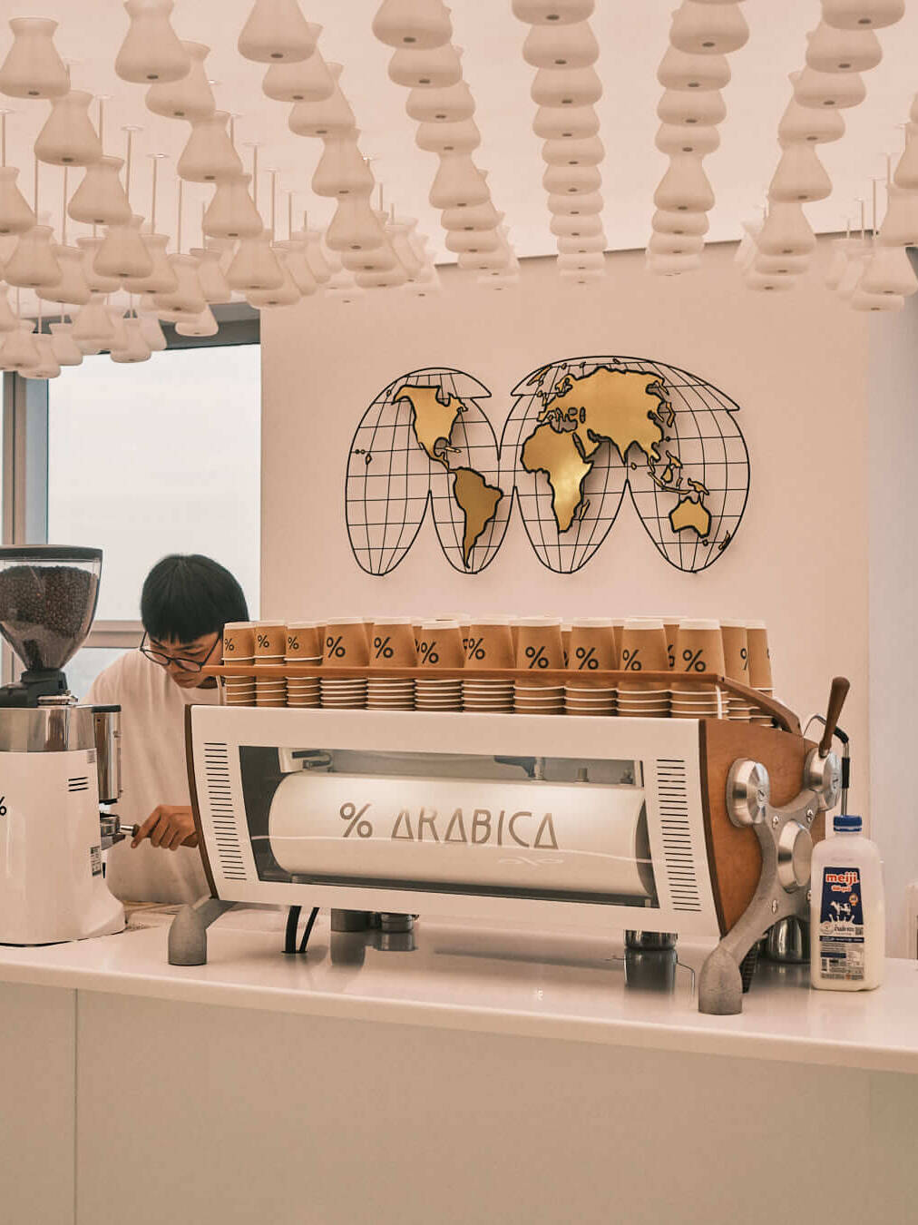 A stylish barista station at Arabica café, blending functionality and sleek design with a breathtaking view of Bangkok.
