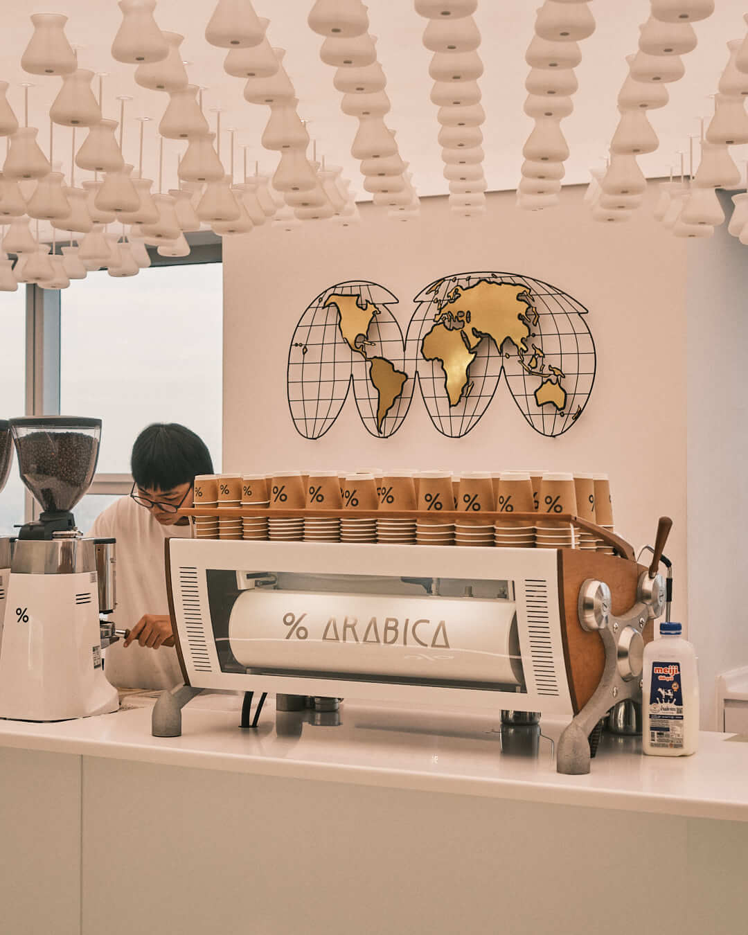 A stylish barista station at Arabica café, blending functionality and sleek design with a breathtaking view of Bangkok.