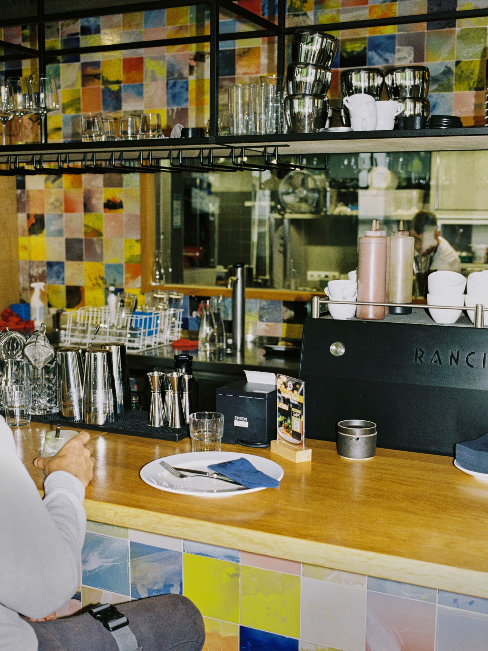 Colorful tiled espresso bar with Rancilio coffee machine inside Frühstück 3000 restaurant in Berlin.