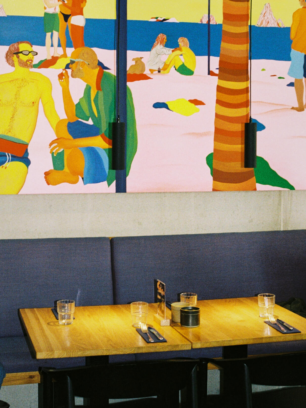 Interior shot of modern dining tables and bright pop-art wall painting at Frühstück 3000 Kreuzberg.