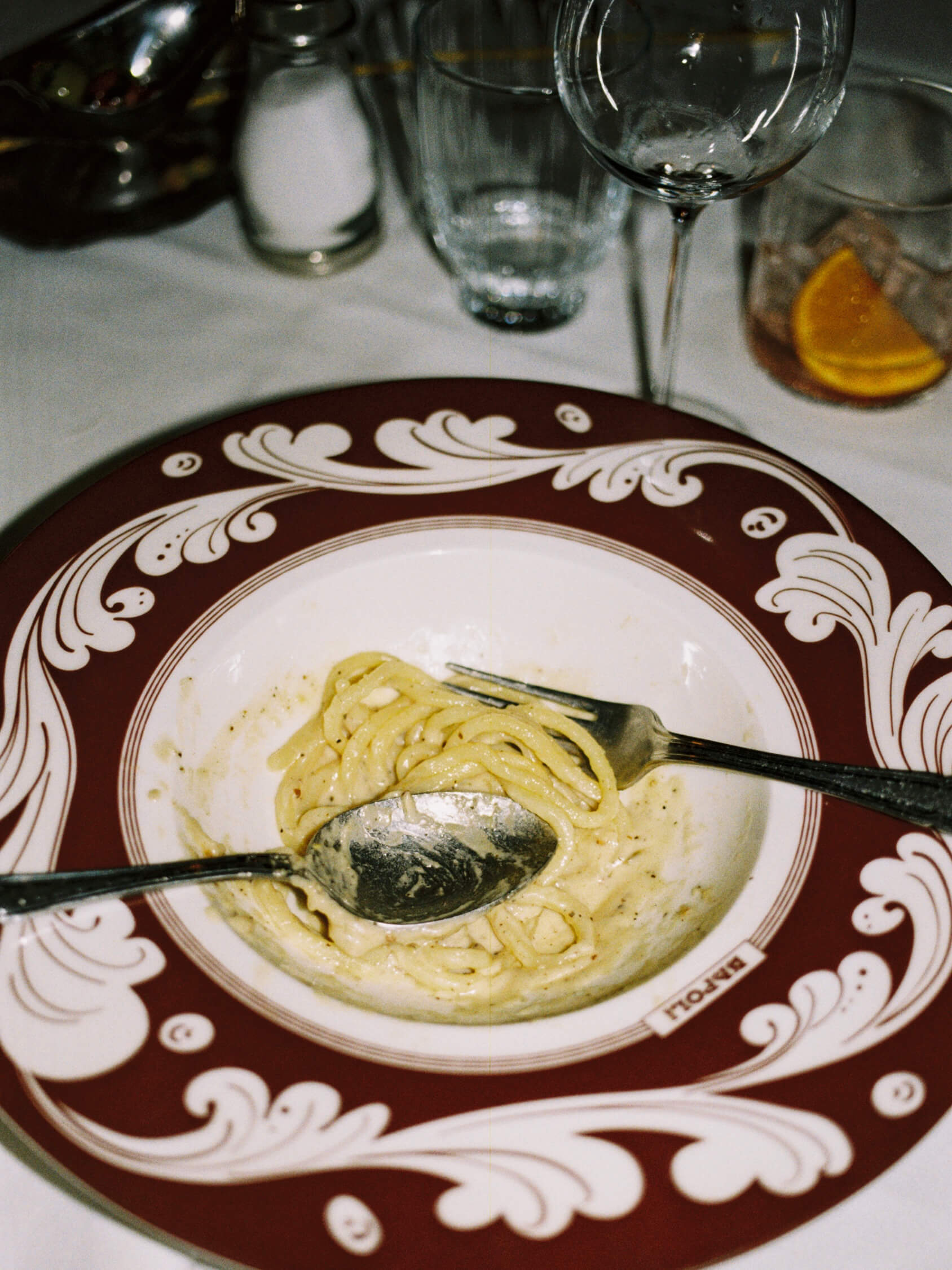 Creamy Cacio e Pepe pasta served with silver cutlery in an ornate ceramic bowl at Pamela Italian restaurant.
